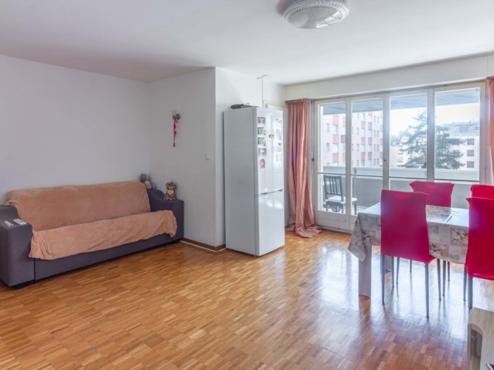 Salon lumineux avec parquet et accès au balcon – appartement 2 pièces Clarens