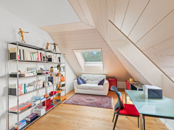 Bureau sous combles avec canapé, bibliothèque et éclairage naturel