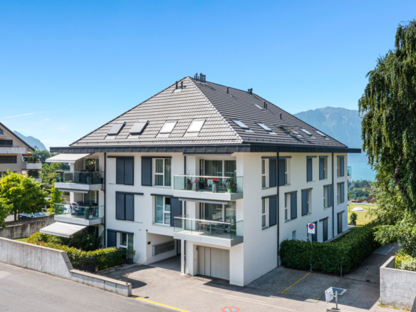 Immeuble moderne avec balcons vitrés et toiture à pans inclinés