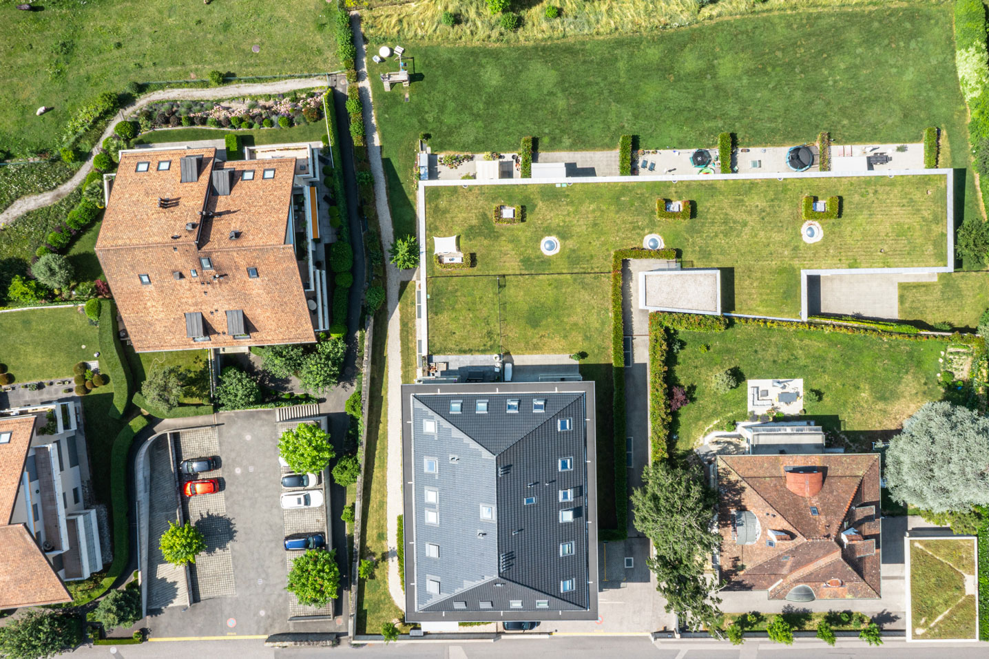 Vue aérienne verticale d’un quartier résidentiel verdoyant avec immeubles récents et jardins privatifs