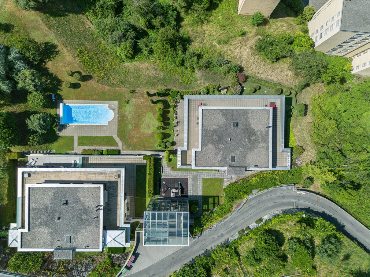 Vue aérienne de deux immeubles résidentiels contemporains avec piscine extérieure et espaces verts à Montreux