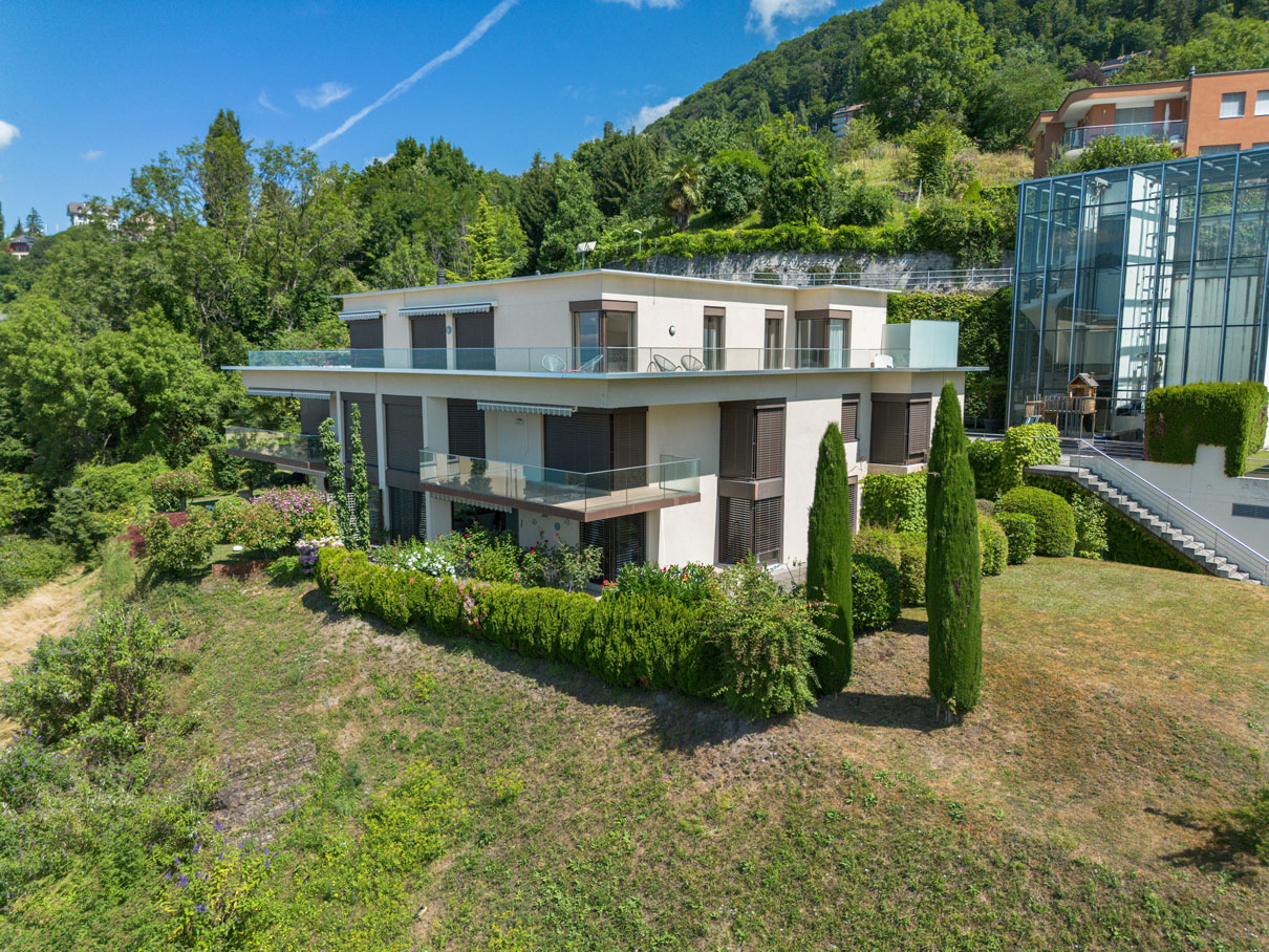 Façade contemporaine d’un immeuble résidentiel entouré de nature à Montreux