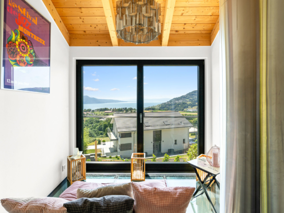 Coin lecture cosy avec coussins et vue dégagée sur le lac Léman à St-Légier