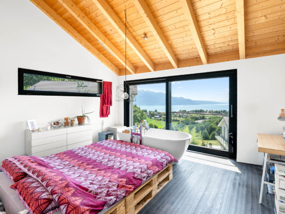 Chambre parentale lumineuse avec baignoire îlot et vue dégagée sur le lac Léman à St-Légier