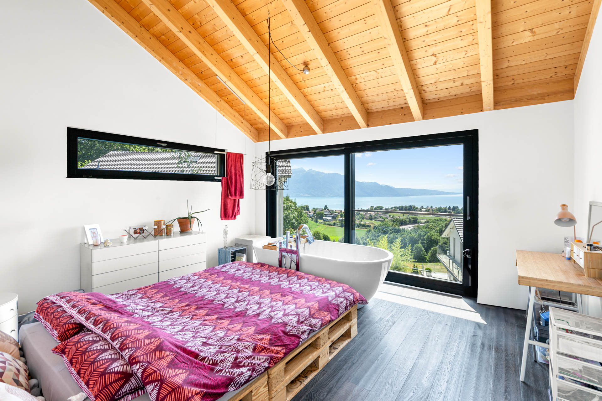 Chambre parentale lumineuse avec baignoire îlot et vue dégagée sur le lac Léman à St-Légier