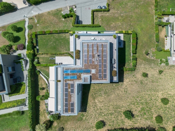 Vue aérienne verticale d’un immeuble avec toiture végétalisée et panneaux solaires