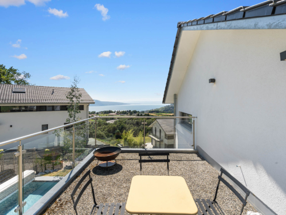 Terrasse en gravier avec mobilier extérieur et vue panoramique sur le lac à St-Légier