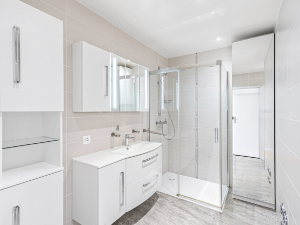Deuxième salle de bains avec douche vitrée et meuble double vasque blanc