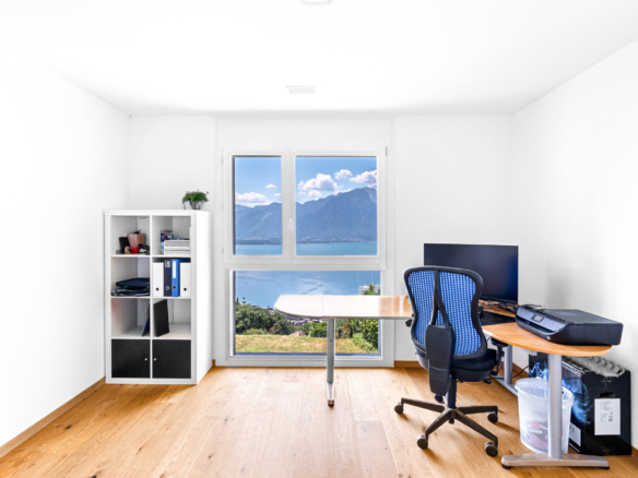 Bureau lumineux avec mobilier en bois clair et vue sur le lac Léman à Chernex