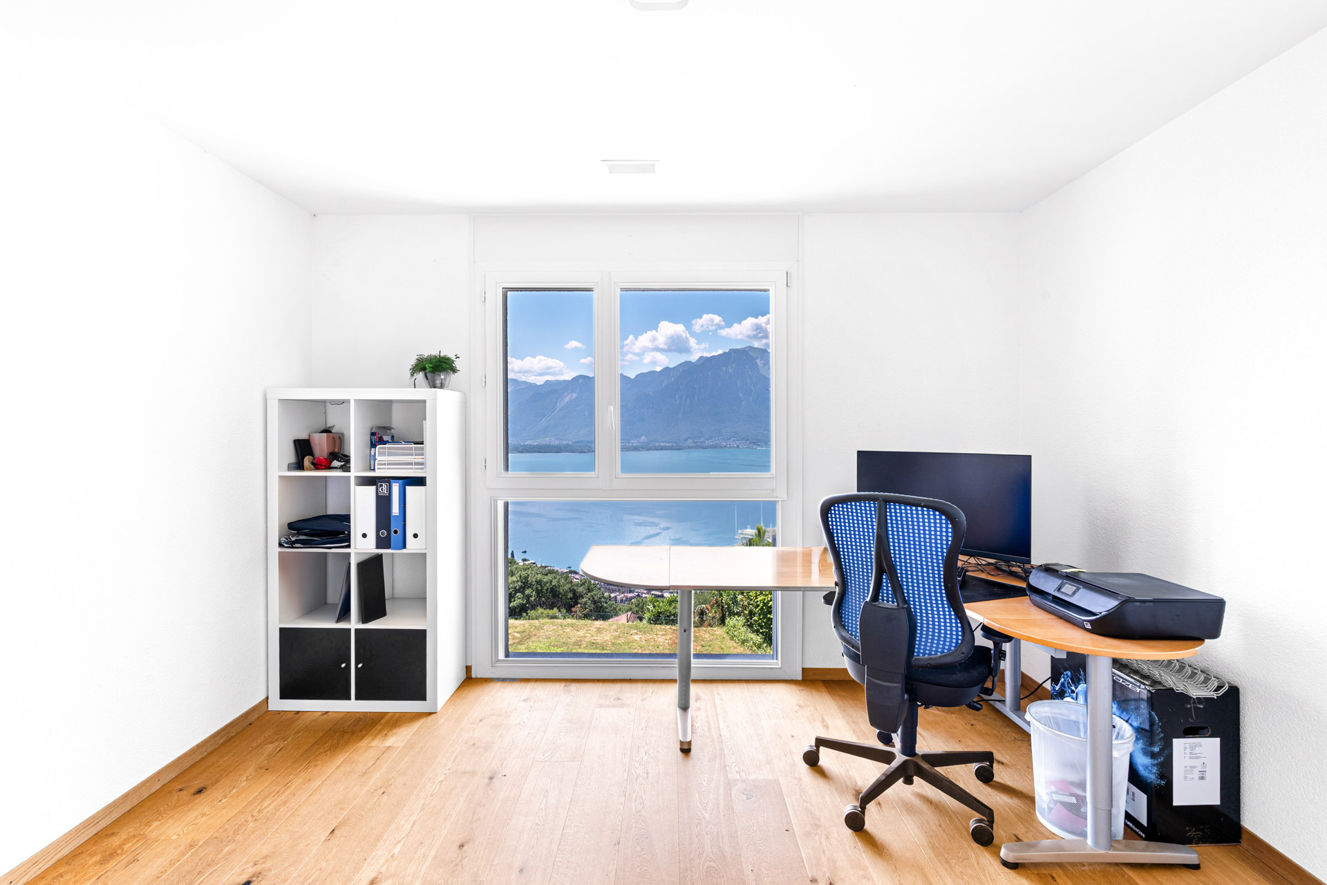 Bureau lumineux avec mobilier en bois clair et vue sur le lac Léman à Chernex