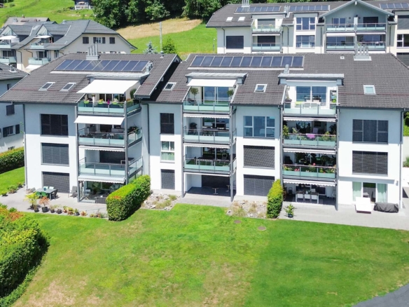 Façade arrière d’un immeuble résidentiel avec terrasses et espaces verts à Chernex
