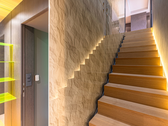 Escalier en bois avec mur texturé et éclairage LED