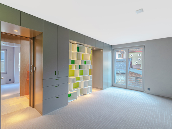 Chambre avec bibliothèque verte intégrée et grande baie vitrée
