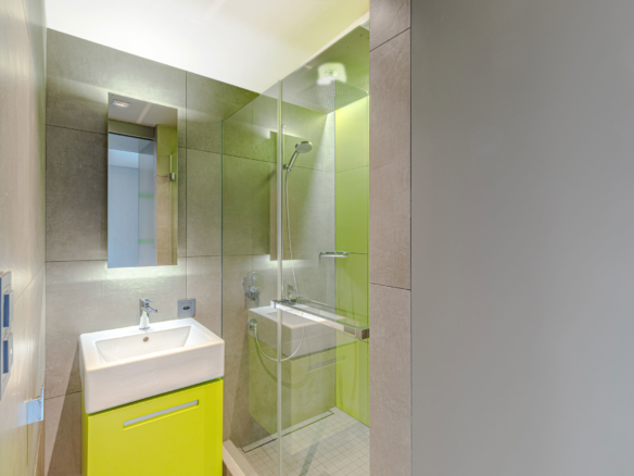 Salle d’eau avec meuble vasque vert et douche vitrée