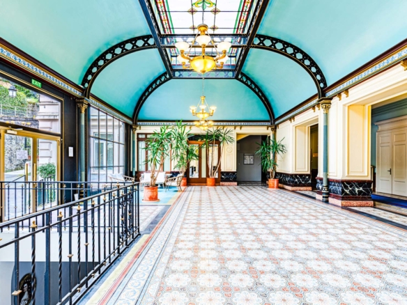 Entrée majestueuse d’un bâtiment Belle Époque avec verrière