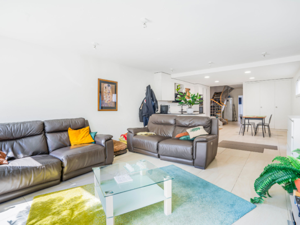 Salon moderne et lumineux à Bournens avec canapés en cuir et grande baie vitrée