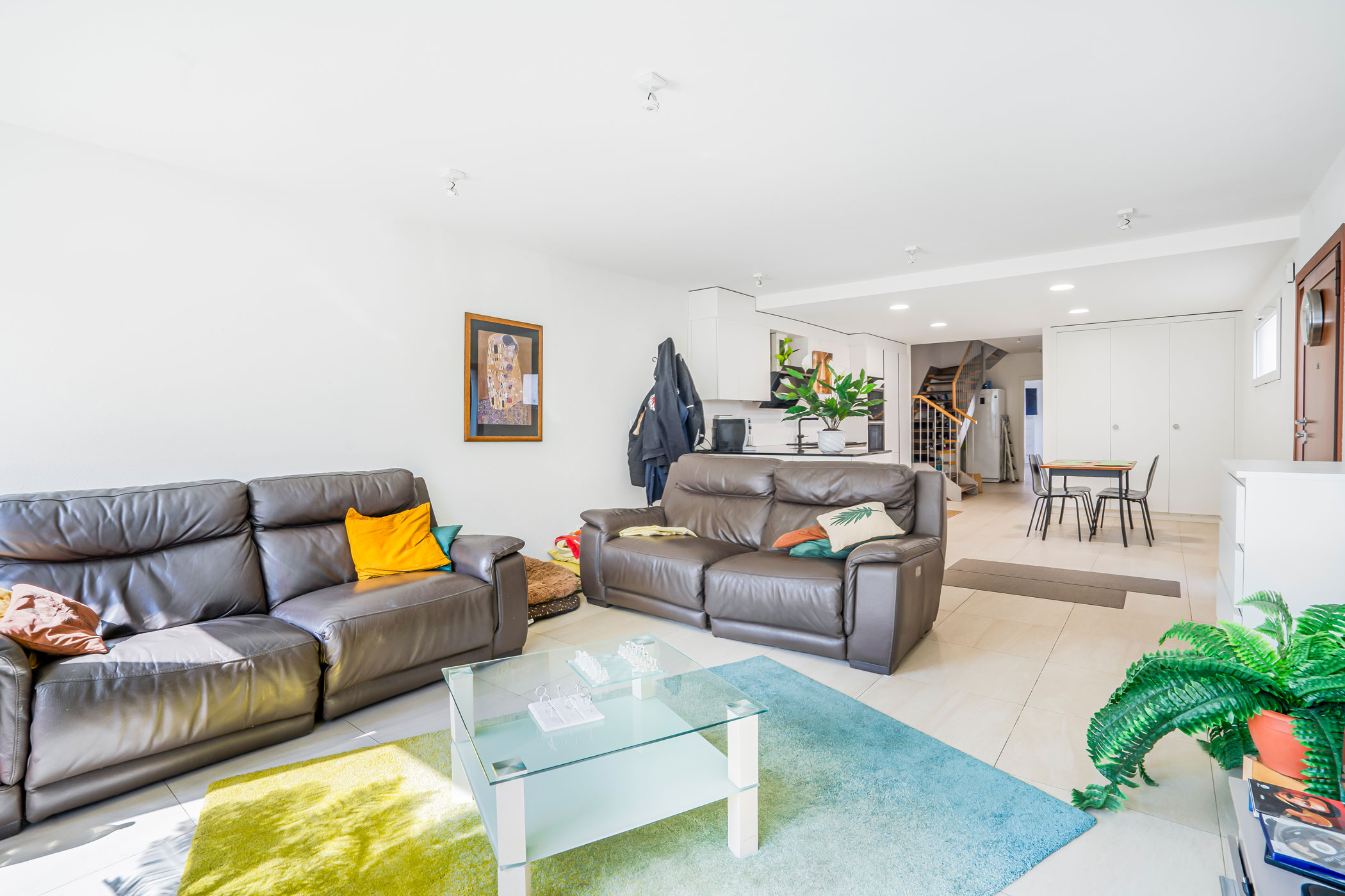 Salon moderne et lumineux à Bournens avec canapés en cuir et grande baie vitrée