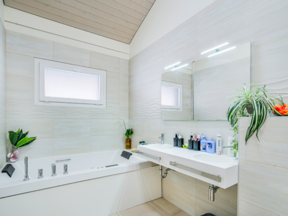 Salle de bain moderne à Bournens avec baignoire balnéo et double vasque