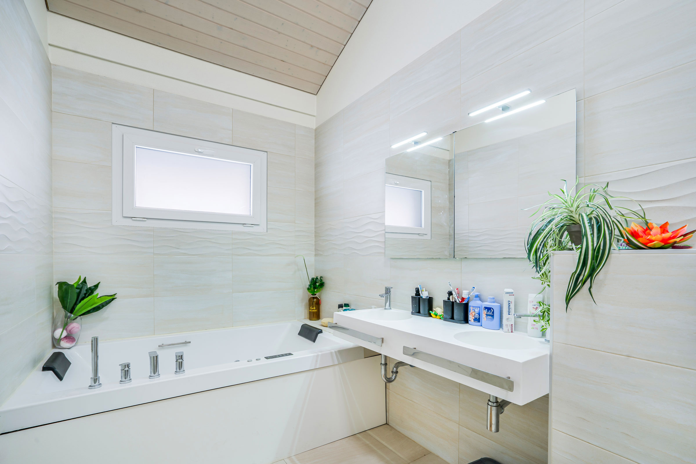 Salle de bain moderne à Bournens avec baignoire balnéo et double vasque
