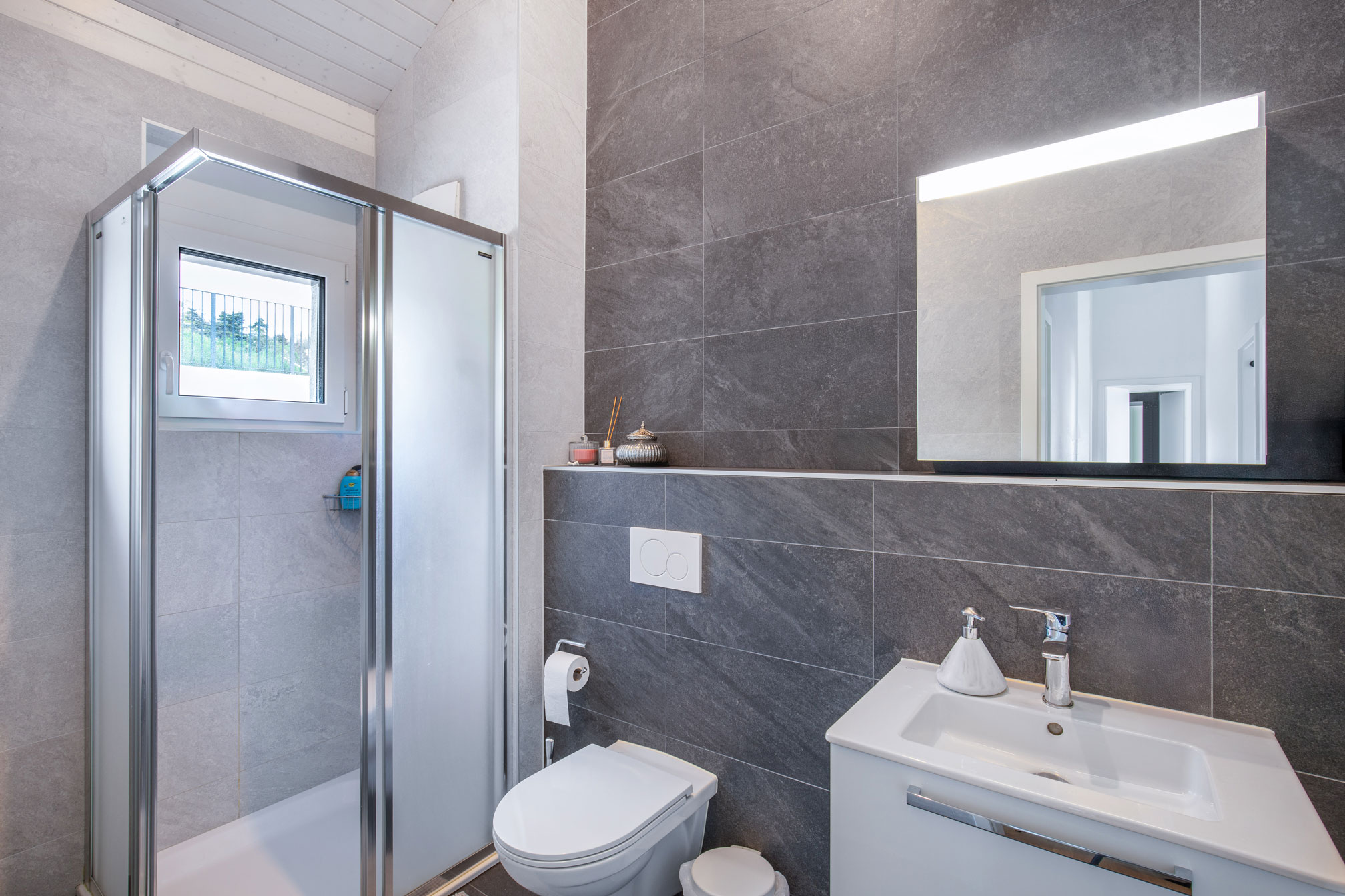 Salle de douche moderne avec carrelage anthracite – Jongny