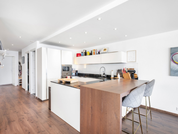 Cuisine moderne à Chardonne avec bar en bois et rangements blancs