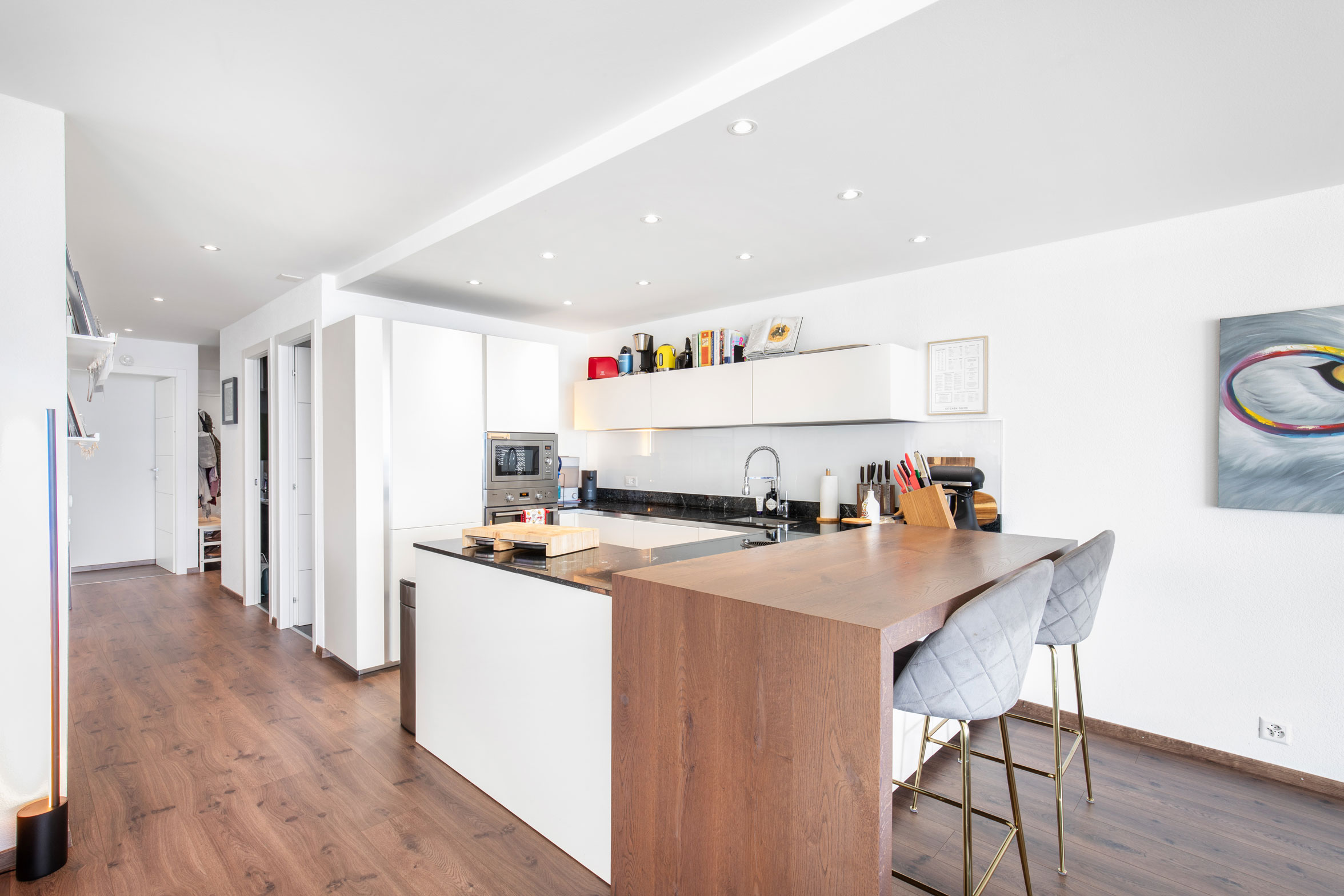 Cuisine moderne à Chardonne avec bar en bois et rangements blancs