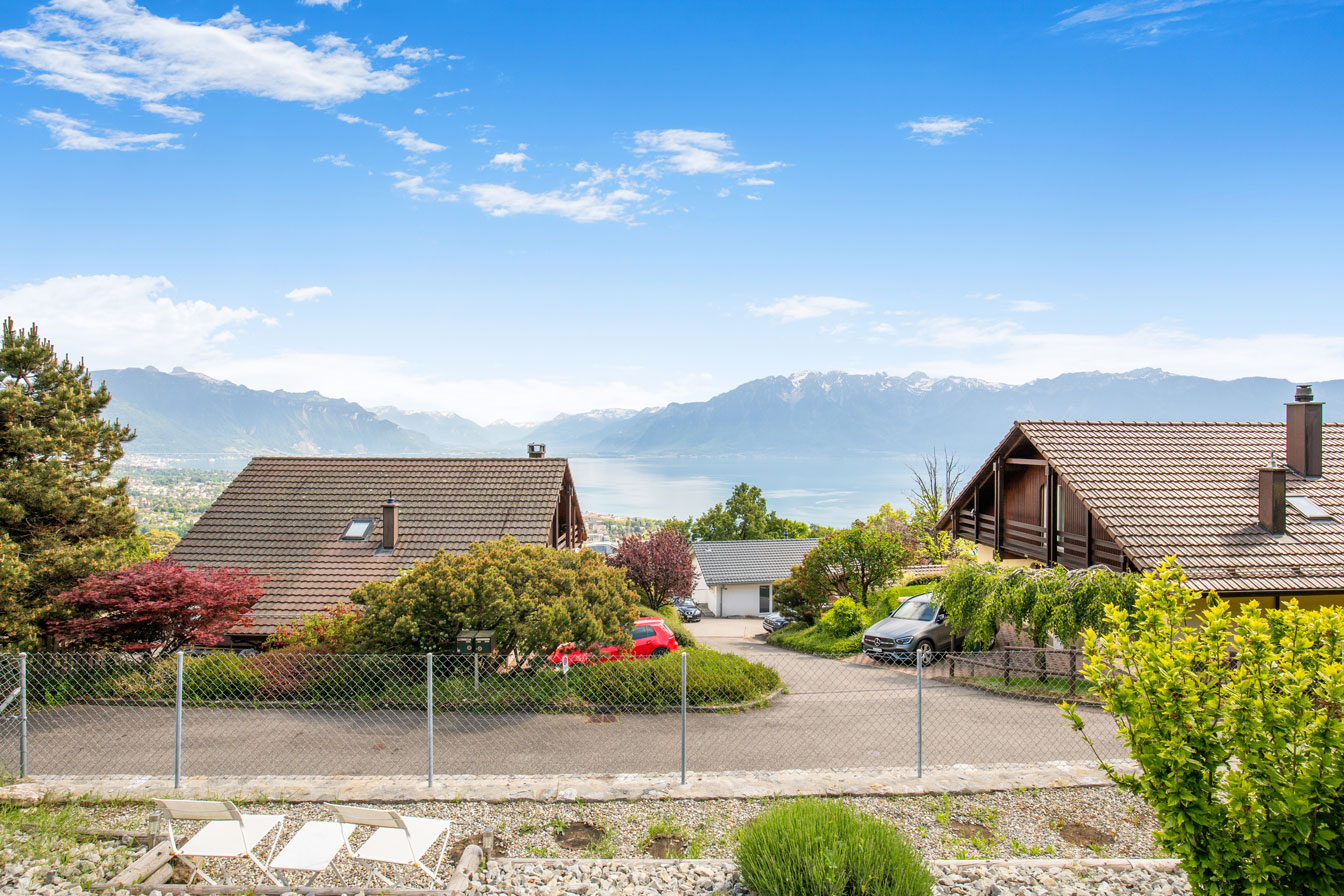 Vue sur les toits de Chardonne et le lac Léman avec les montagnes en fond