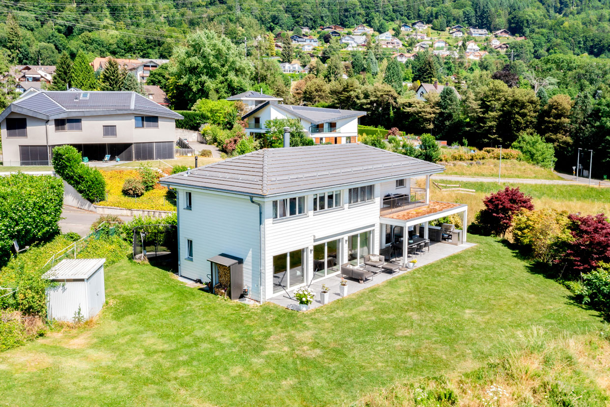 Maison moderne avec grande terrasse et jardin entretenu, dans un quartier résidentiel verdoyant de Blonay.