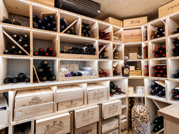 Cave à vin en bois avec casiers sur mesure et nombreuses bouteilles rangées avec soin.