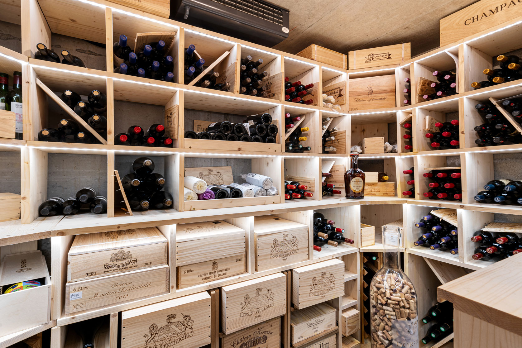 Cave à vin en bois avec casiers sur mesure et nombreuses bouteilles rangées avec soin.