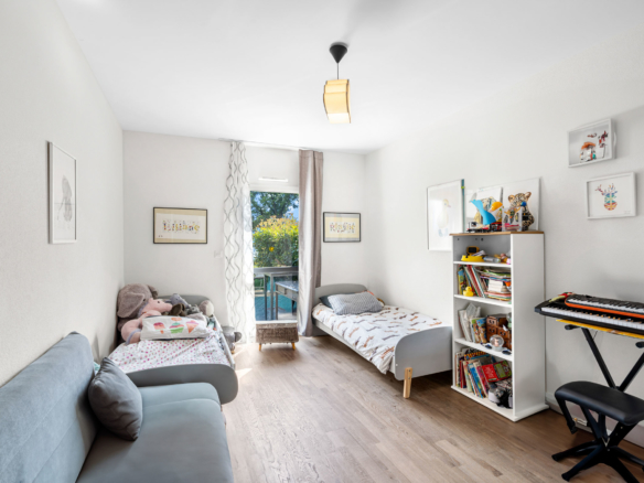 Chambre d’enfant lumineuse avec deux lits, bibliothèque et jouets