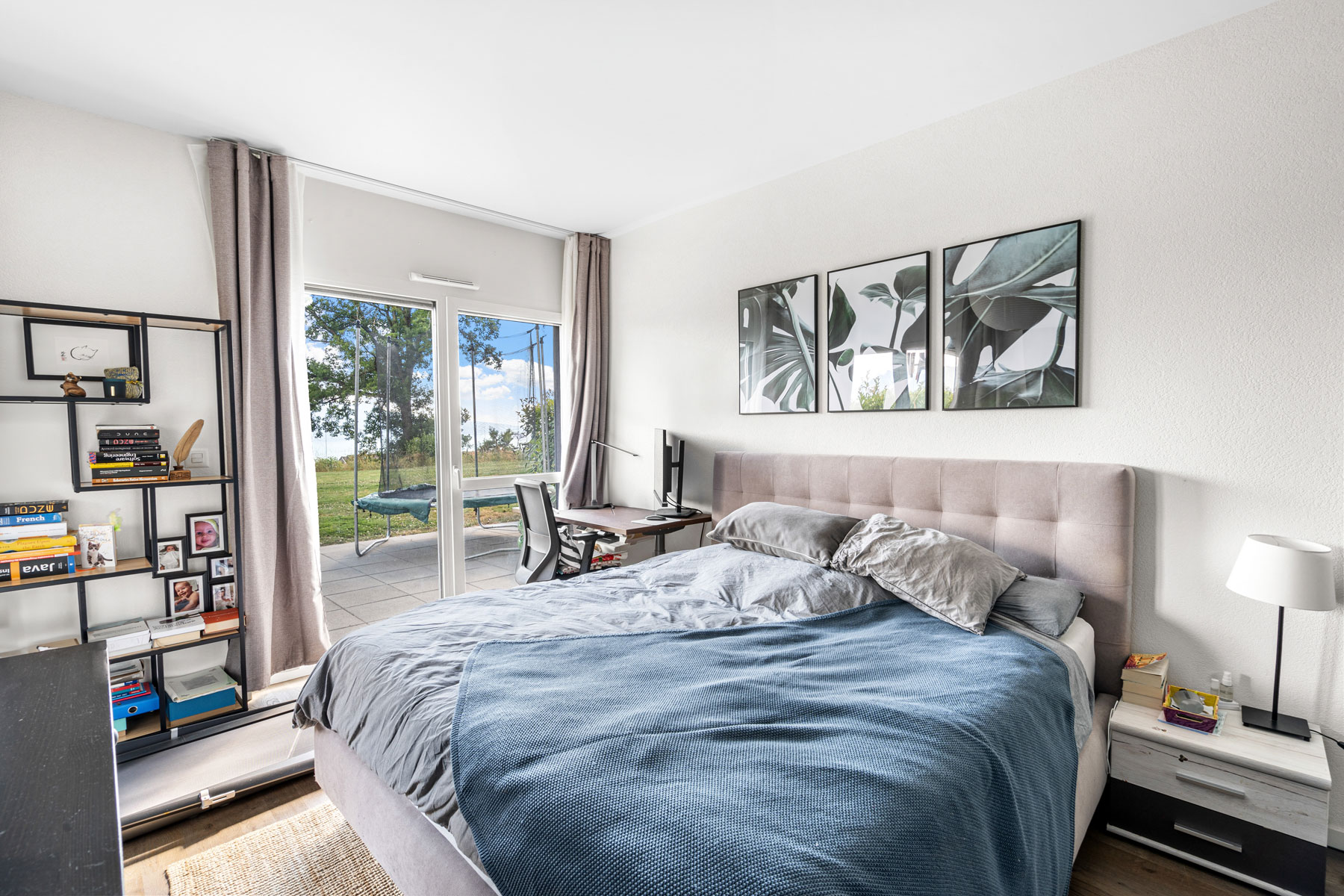 Chambre parentale avec lit double, bureau et accès terrasse vitrée