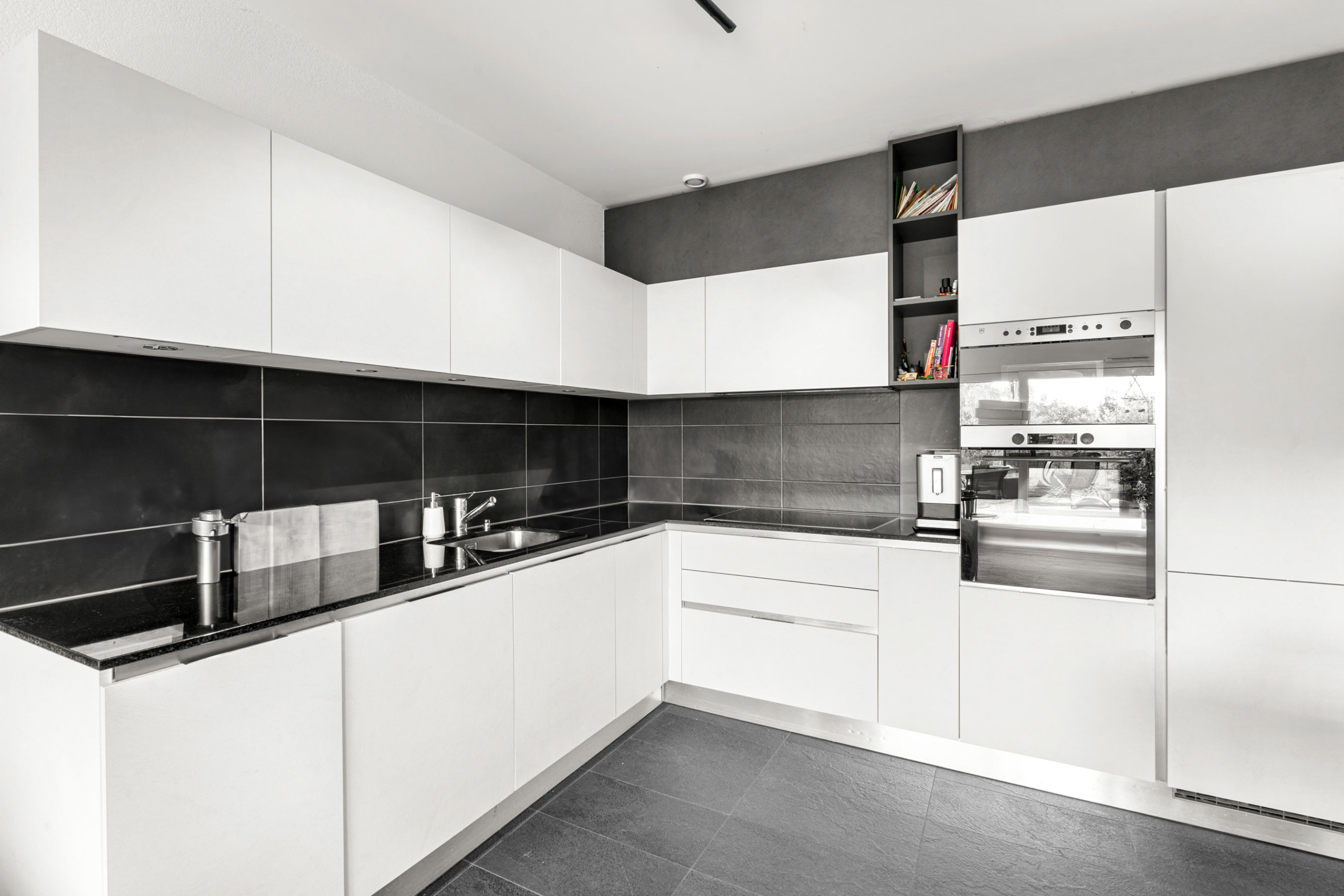Cuisine blanche contemporaine en angle avec électroménager encastré et plan de travail noir