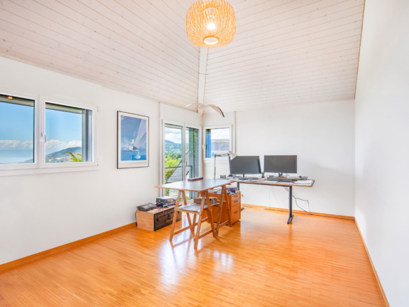 Grand bureau sous toiture avec deux postes de travail, parquet et vue lac.