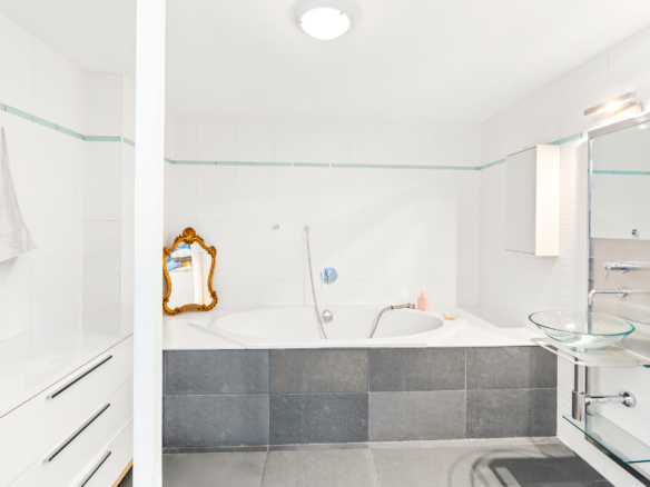 Salle de bain moderne avec baignoire d’angle et miroir doré