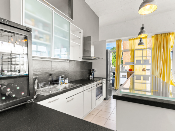 Cuisine moderne ouverte avec plan de travail noir et rangements blancs