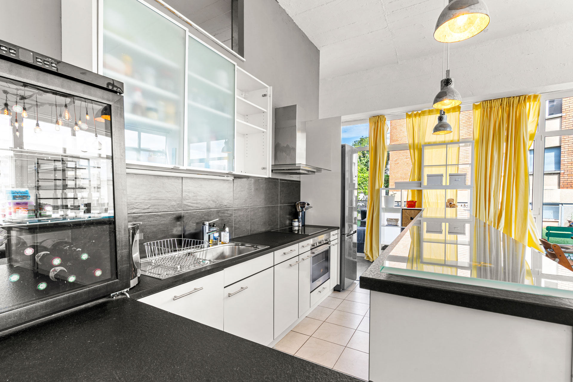 Cuisine moderne ouverte avec plan de travail noir et rangements blancs
