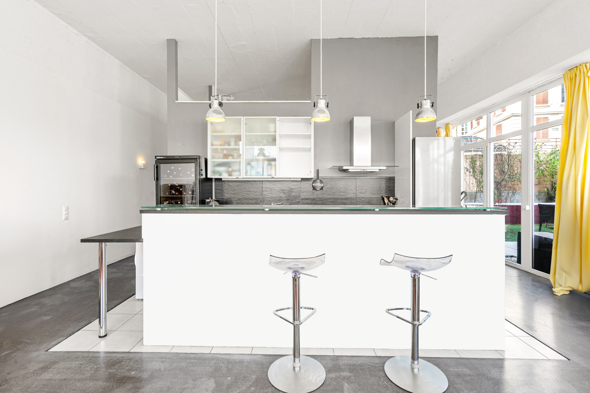 Cuisine ouverte avec îlot central et chaises hautes design