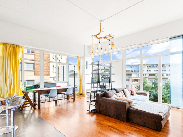 Salon design avec parquet, baies vitrées et rideaux jaunes
