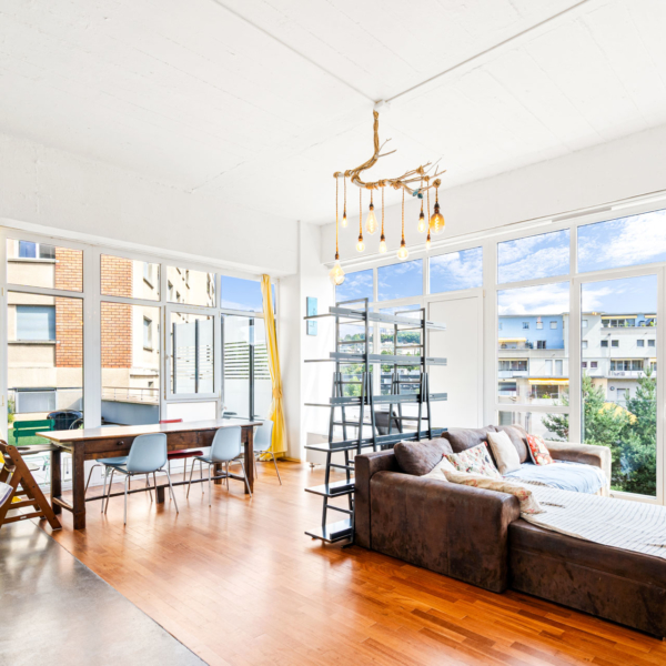 Salon design avec parquet, baies vitrées et rideaux jaunes