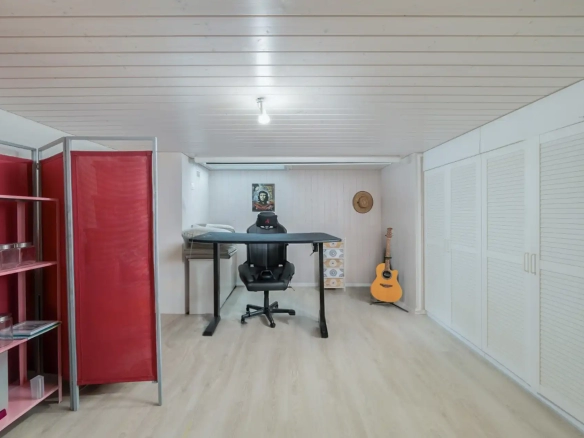 Bureau mansardé avec espace de travail, guitare et rangements