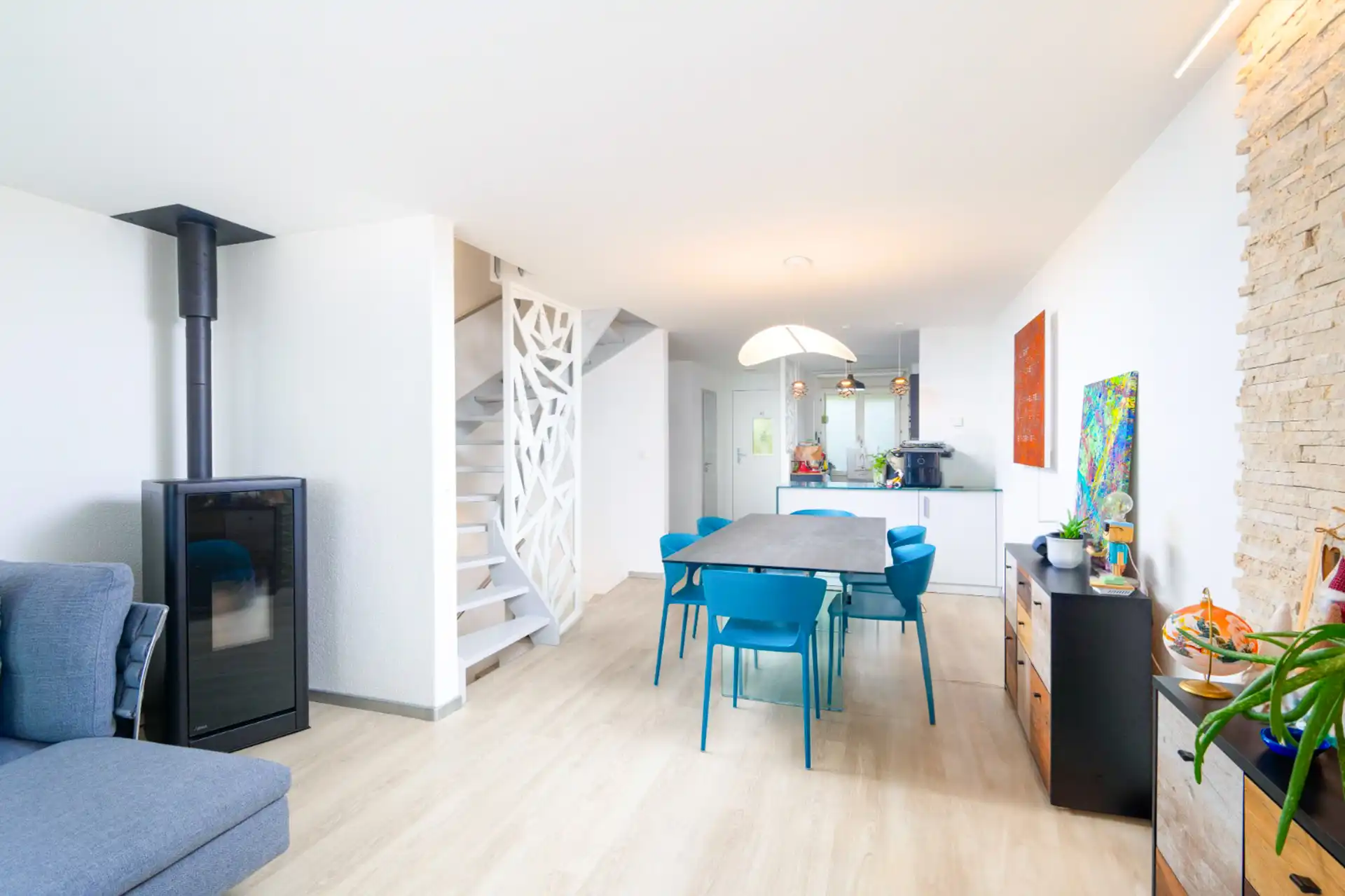 Salle à manger ouverte sur cuisine moderne et escalier design