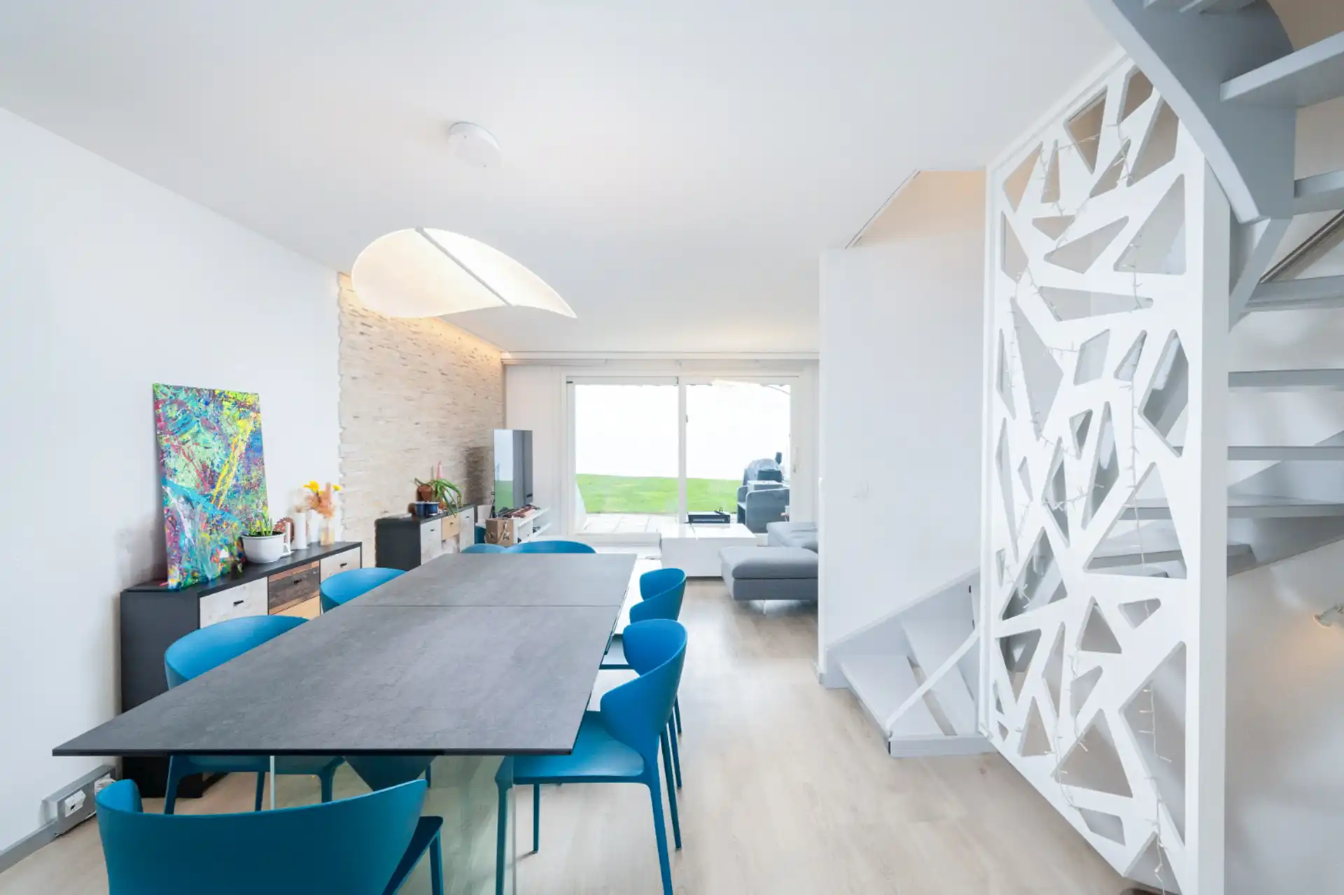 Salle à manger spacieuse avec table et chaises bleues, décoration design