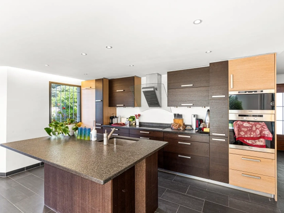 Cuisine moderne équipée avec îlot central et rangements.