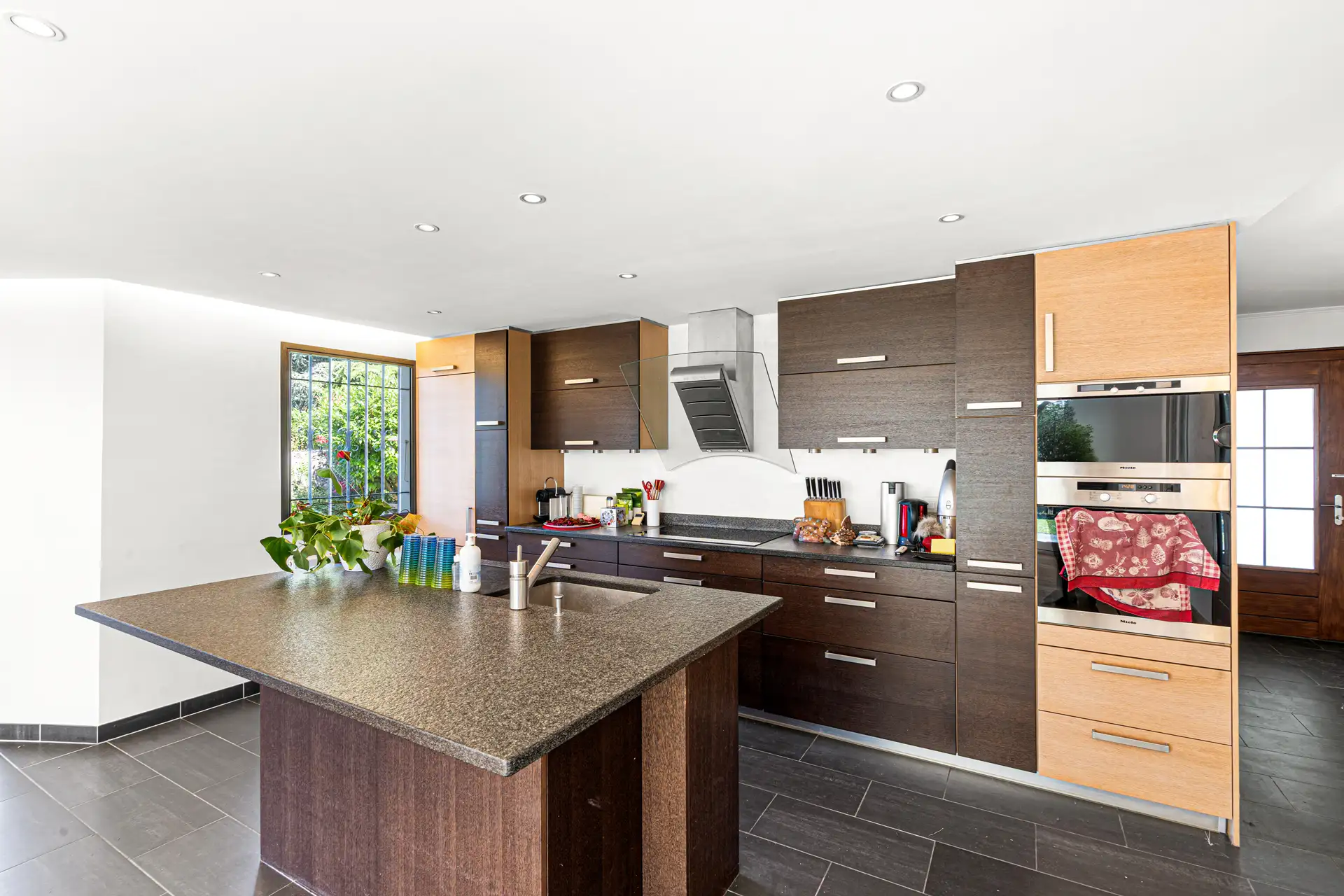 Cuisine moderne équipée avec îlot central et rangements.