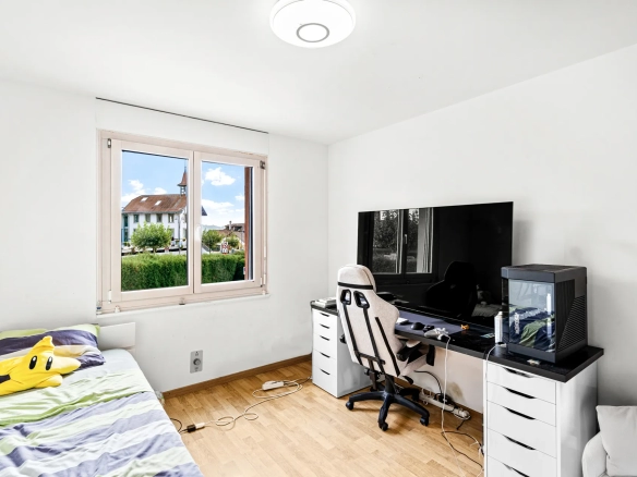 Chambre lumineuse avec bureau et espace de travail