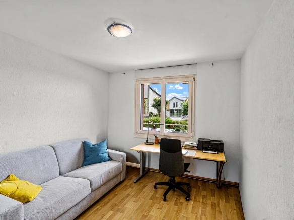 Chambre transformée en espace bureau avec canapé