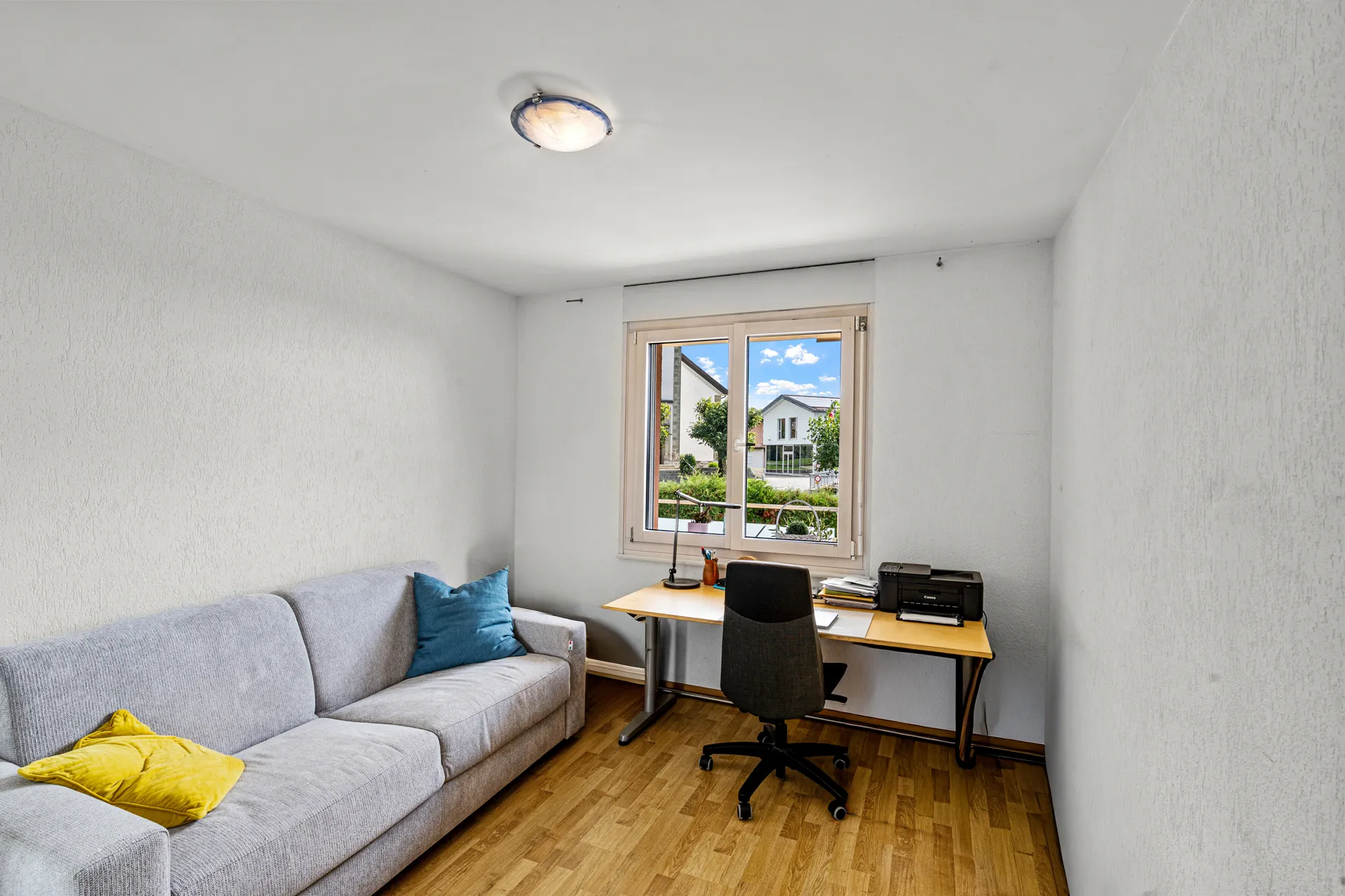Chambre transformée en espace bureau avec canapé