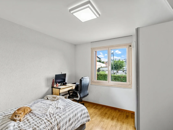 Chambre meublée avec bureau et grande fenêtre