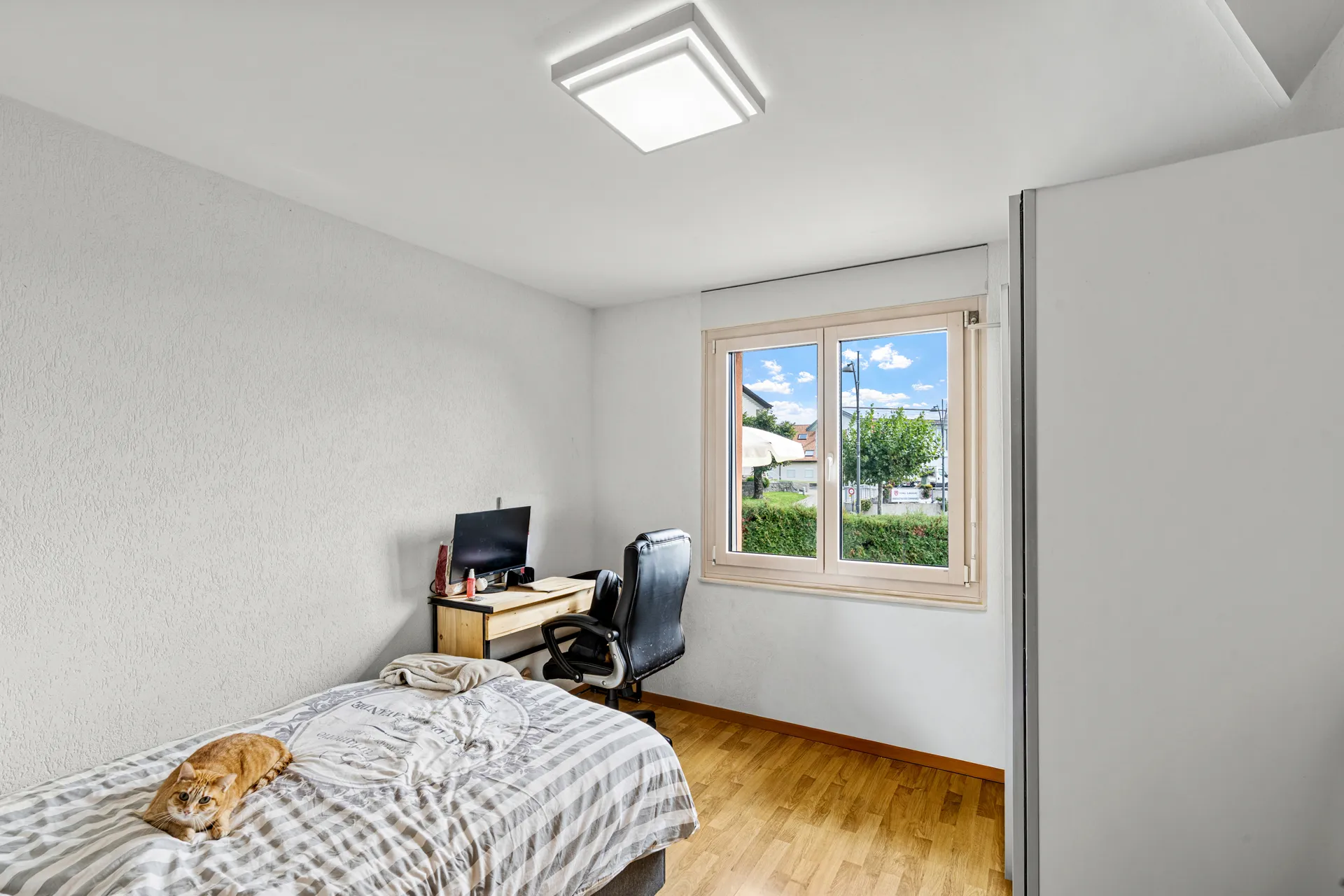 Chambre meublée avec bureau et grande fenêtre